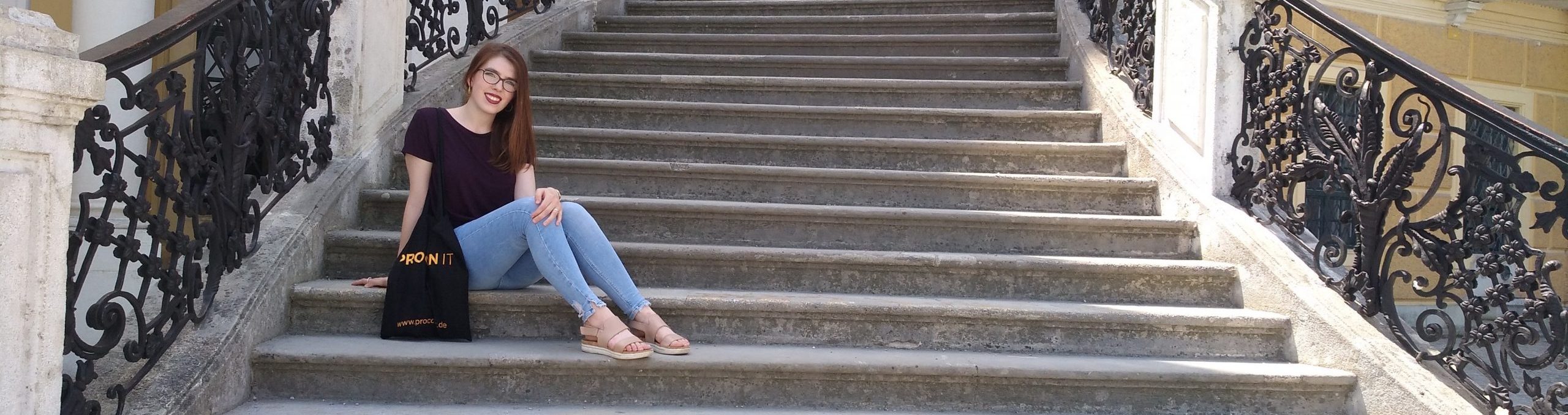 Lauren K., the sassy expat, sitting on the steps of Schönbrunn Palace in Vienna.